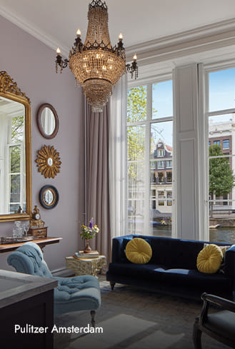 A beautiful chandelier hanging in the Antique Collector’s Suite of Pulitzer Amsterdam, with the full view of the canal.