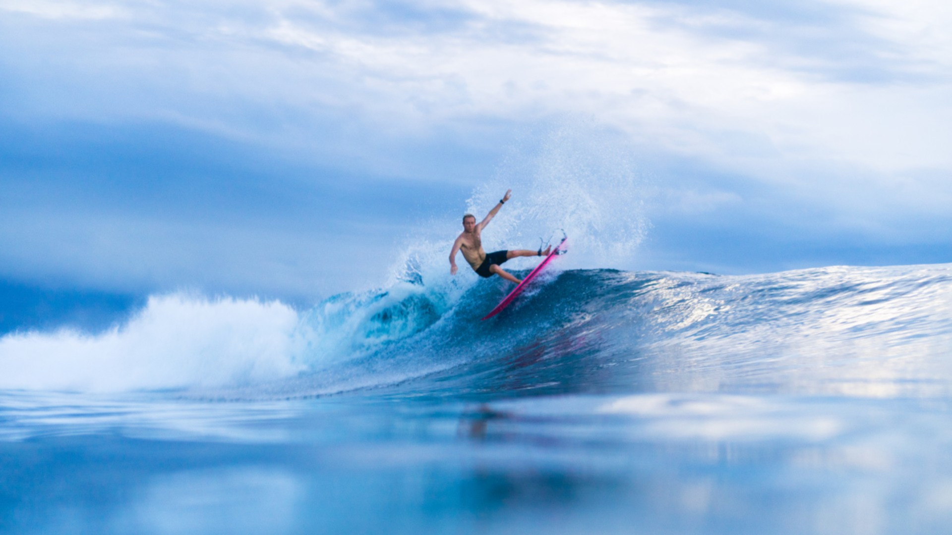 Surfer riding a wave near Naladhu Private Island Maldives